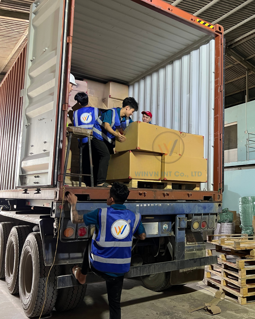 Team loading boxes onto container truck